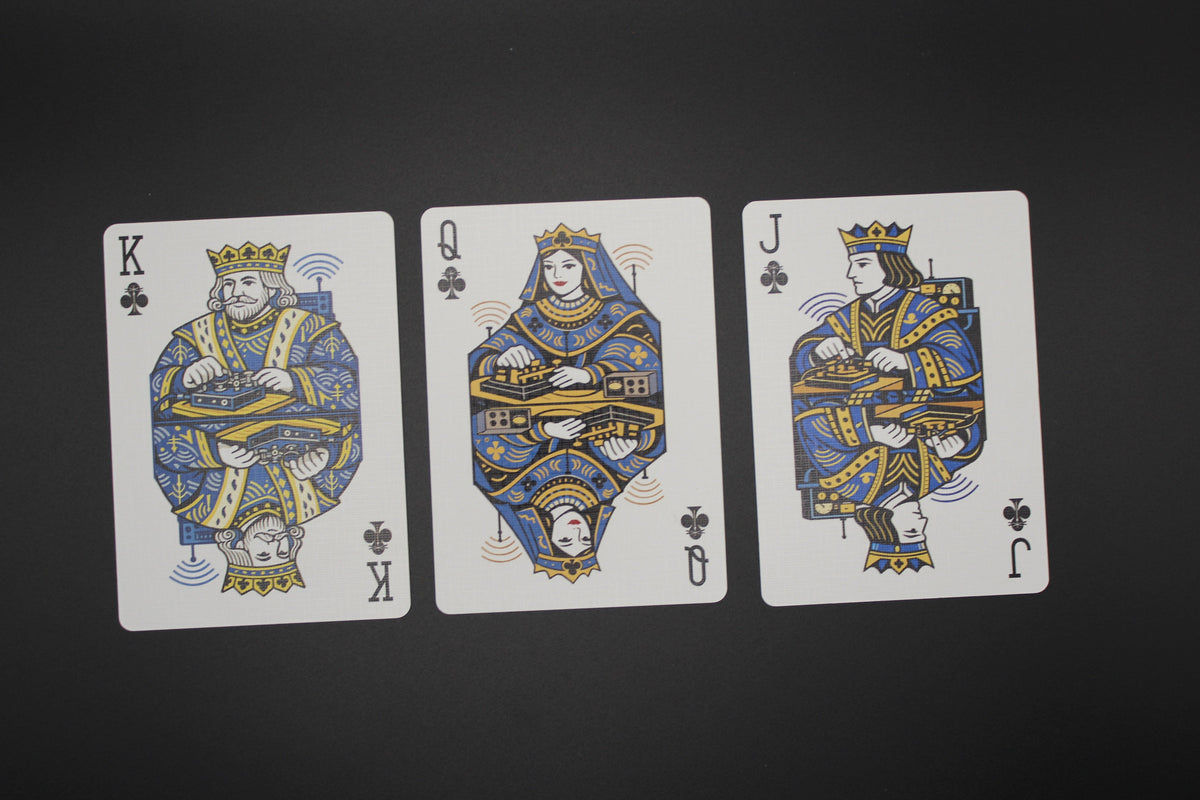 Three playing cards featuring King, Queen, and Jack of Clubs on a black background