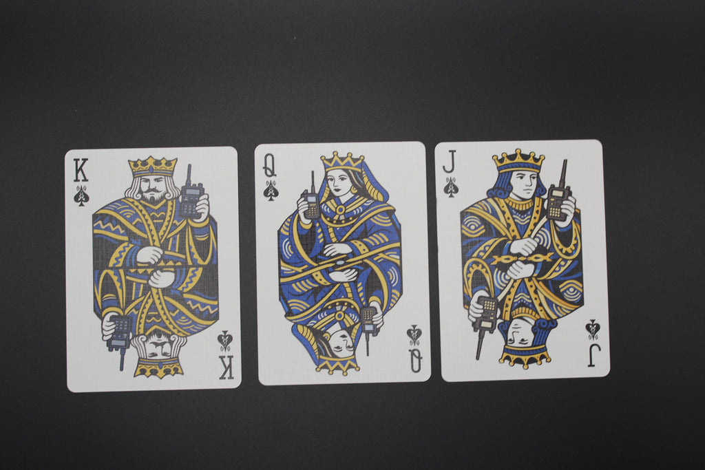 Three playing cards featuring a king, queen, and jack with unique designs on a black background.