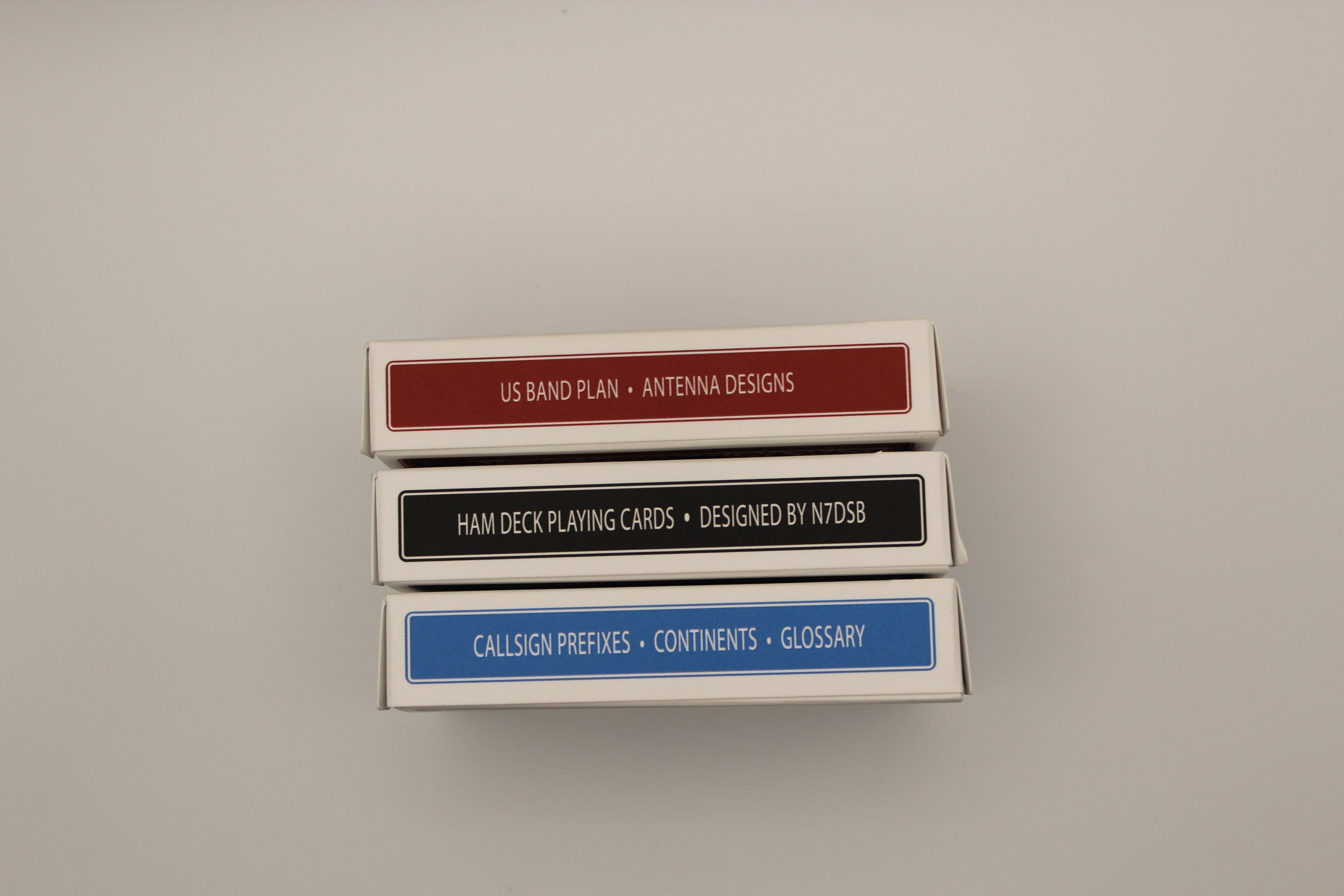 Three card decks stacked on a gray background