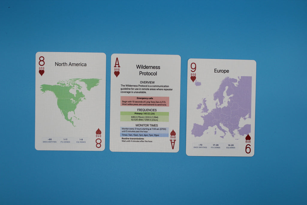 Three playing cards with world map designs on a blue background