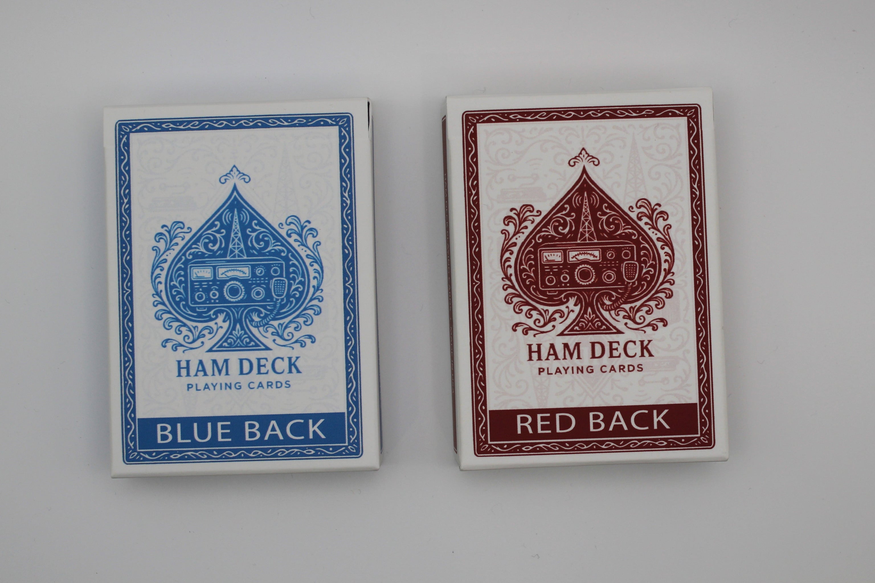 Two playing card decks, one with blue back and one with red back, on a gray background.