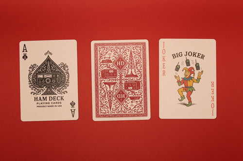 Three playing cards from different decks on a red background